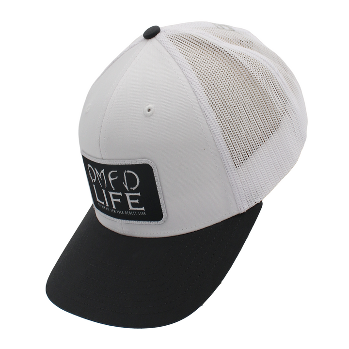Side of a white hat with a grey bill and a black patch on the front.