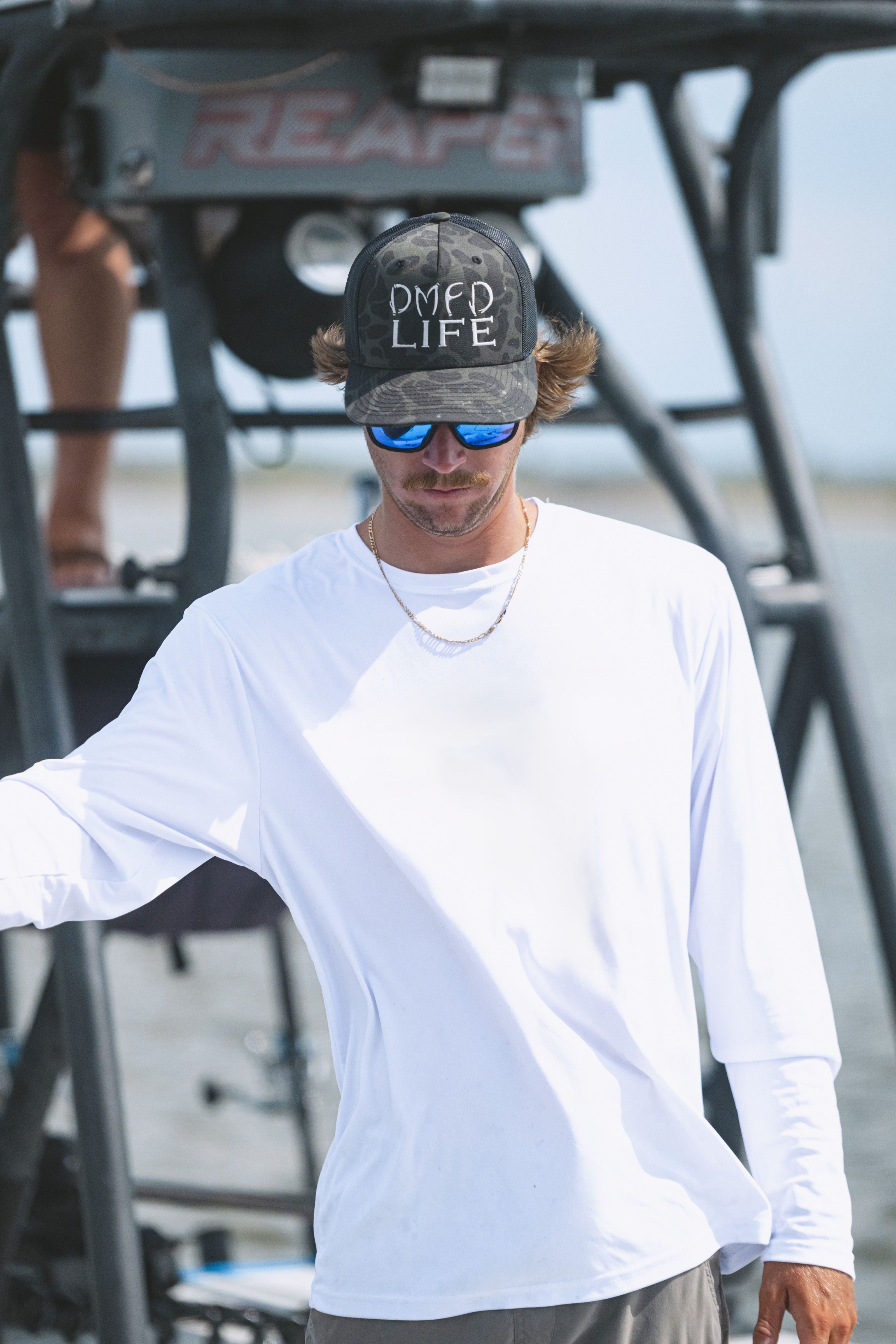 Captain Liam Garvey wearing a DMFD Life camo hat on the Skiff on Mosquito Lagoon