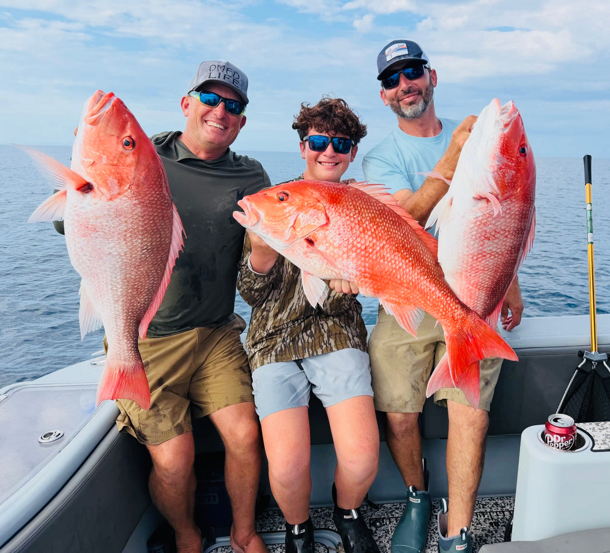 Three people on the DMFD Life Insetta 35IFC Charter Fishing boat holding large red snapper with Robert Arrington 