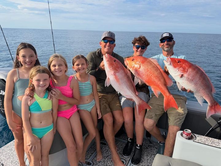 Family on a DMFD Life Insetta 35IFC Charter Fishing boat with large red fish